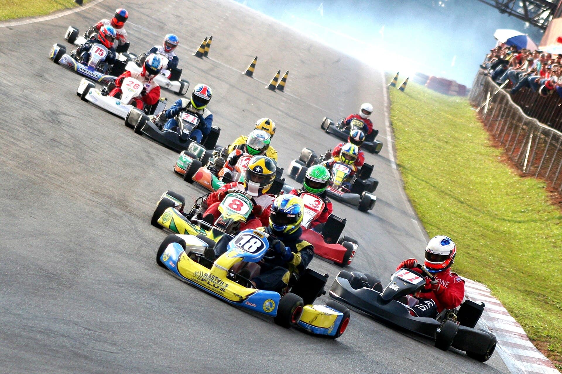 Pelotão de karts lado a lado logo depois da largada, numa pista brasileira